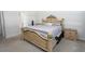 Bedroom featuring a large bed frame, neutral carpeting and walls, and adjacent bathroom at 146 Loblolly Ln, Davenport, FL 33837