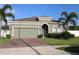 Charming single-story home featuring a two-car garage, brick-paved driveway, and lush green lawn at 146 Loblolly Ln, Davenport, FL 33837