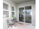 Cozy patio area with outdoor seating, windows, and sliding glass doors offering natural light and backyard access at 146 Loblolly Ln, Davenport, FL 33837