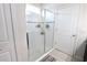 Walk-in shower featuring decorative tile accents, glass door, and adjacent bathroom at 146 Loblolly Ln, Davenport, FL 33837