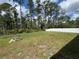 Spacious backyard featuring a fire pit area, framed by tall trees and a white vinyl fence at 1476 11Th Ave, Deland, FL 32724