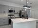 Modern kitchen featuring stainless steel appliances, gray cabinets, and a quartz countertop island at 1476 11Th Ave, Deland, FL 32724