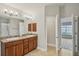 Well-lit bathroom featuring a double vanity, a shower, and neutral tile flooring at 1846 Galloway Ter, Winter Haven, FL 33881
