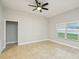 A large bedroom with tile floors, ceiling fan, and a window bringing in natural light at 1846 Galloway Ter, Winter Haven, FL 33881