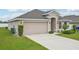 Charming single-story home with a two-car garage, well-maintained lawn and decorative shrubs and trees at 1846 Galloway Ter, Winter Haven, FL 33881