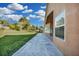 Spacious backyard with a long walkway, lush lawn, and mature trees under a sky dotted with fluffy clouds at 1940 Southern Dunes Blvd, Haines City, FL 33844