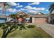 Charming single-story home with a well-manicured lawn, palm trees, and a two-car garage at 1940 Southern Dunes Blvd, Haines City, FL 33844