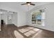 Sun-filled living room with wood-look flooring, a ceiling fan, and an arched window with an inviting view at 1940 Southern Dunes Blvd, Haines City, FL 33844