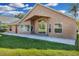 Tan home featuring a wide concrete patio, expansive windows, and a neatly kept lawn under a blue sky at 1940 Southern Dunes Blvd, Haines City, FL 33844