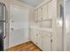 An open kitchen features white cabinets, countertops, and wood flooring at 200 Saint Andrews Blvd # 1603, Winter Park, FL 32792
