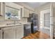 Kitchen with stainless steel appliances, white countertops, wood-look floors, and a sunlit window at 200 Saint Andrews Blvd # 1603, Winter Park, FL 32792