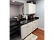 The kitchen has stainless steel appliances and white cabinets with wood flooring at 2035 Dixie Belle Dr # 2035C, Orlando, FL 32812