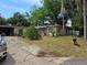 Exterior view of home with mature trees, landscaping, and a gray truck in the driveway at 2464 Lotafun Ave, Winter Park, FL 32789
