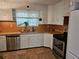 Bright kitchen featuring white cabinets, a stainless steel dishwasher, and a double basin sink at 2464 Lotafun Ave, Winter Park, FL 32789