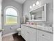 Bright bathroom features a granite countertop, modern vanity, and frosted window at 2770 Windsorgate Ln, Orlando, FL 32828