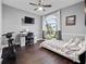 Cozy bedroom featuring modern desk, ceiling fan and a bright window overlooking the backyard at 2770 Windsorgate Ln, Orlando, FL 32828