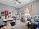 Comfortable bedroom featuring ample desk and storage space, a ceiling fan and cozy carpeted floors at 2770 Windsorgate Ln, Orlando, FL 32828