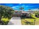 Aerial view of the large neutral colored home with lush lawn and lake views on a bright, sunny day at 2770 Windsorgate Ln, Orlando, FL 32828