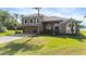 Two-story home featuring a neutral stone facade, manicured lawn, and lush, green shrubbery at 2770 Windsorgate Ln, Orlando, FL 32828