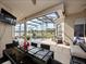 Covered patio with a dining set overlooking a screened-in pool and lake view, perfect for outdoor entertaining and relaxation at 2770 Windsorgate Ln, Orlando, FL 32828