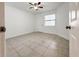 Cozy bedroom with neutral tile flooring, a ceiling fan, and a window providing natural light at 3028 Parkway Blvd # 105, Kissimmee, FL 34747