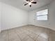 Bright bedroom with neutral tile flooring, a ceiling fan, and a window for natural light at 3028 Parkway Blvd # 105, Kissimmee, FL 34747