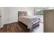 Cozy bedroom features a comfortable bed, hardwood floors, neutral walls, and ample natural light, creating a serene space at 3294 S Semoran Blvd # 14, Orlando, FL 32822