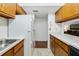 Functional kitchen layout featuring classic wood cabinetry, white countertops, and view to the living room at 3294 S Semoran Blvd # 14, Orlando, FL 32822