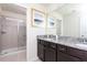 Bathroom with granite countertops, undermount sinks, framed mirror, and tiled walk-in shower at 3413 Lilac, Davenport, FL 33897
