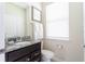 A well-lit half-bath with a granite vanity, decorative mirror and modern fixtures at 3413 Lilac, Davenport, FL 33897
