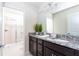 Bathroom with double sink vanity, granite countertop, and tile shower with glass doors at 3413 Lilac, Davenport, FL 33897
