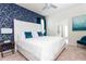 Stylish bedroom featuring a large bed with patterned accent wall and ensuite bathroom access at 3413 Lilac, Davenport, FL 33897
