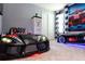 The bedroom features two race car beds, gas pump decor and black and white curtains at 3413 Lilac, Davenport, FL 33897