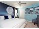 Modern bedroom featuring a light blue wall, moon mural, white bed, accent chair, and ceiling fan at 3413 Lilac, Davenport, FL 33897