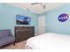 Modern bedroom featuring a blue wall, NASA mural, entertainment center, accent chair, and white bed at 3413 Lilac, Davenport, FL 33897