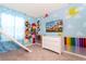 The bedroom features a slide, white dresser and colorful cartoon mural on the walls at 3413 Lilac, Davenport, FL 33897