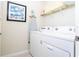 A functional laundry room with a modern washer and dryer, ironing board and decor at 3413 Lilac, Davenport, FL 33897
