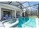 A screened-in pool and jacuzzi area with lounge chairs, offering a luxurious outdoor experience at 3413 Lilac, Davenport, FL 33897