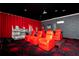 Home theater features red leather reclining chairs, tiered seating, and immersive cityscape mural at 3413 Lilac, Davenport, FL 33897