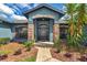 Close-up of the front door and entrance with stone pillars, garden beds, and mature palm at 4037 Se 40Th St, Ocala, FL 34480