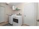 Laundry room with washer, dryer, storage shelf, and a white door at 4037 Se 40Th St, Ocala, FL 34480