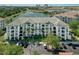 Aerial view of a condo complex with lush landscaping, a lake view, and ample parking, blending luxury with convenience at 4102 Breakview Dr # 30603, Orlando, FL 32819