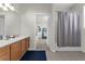 Bright bathroom featuring a wood vanity, large mirror, and tub with shower curtain, offering a clean and functional space at 4102 Breakview Dr # 30603, Orlando, FL 32819