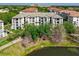 View of condo building with balconies overlooking landscaping and lake at 4102 Breakview Dr # 30603, Orlando, FL 32819