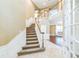 Elegant foyer with a staircase, hardwood flooring, neutral colors, and natural light creates a welcoming entrance at 442 Anessa Rose Loop, Ocoee, FL 34761