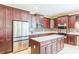 Modern kitchen with cherry cabinets, stainless steel appliances, island and tile backsplash create culinary experience at 442 Anessa Rose Loop, Ocoee, FL 34761