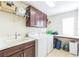 Efficient laundry room features ample cabinet space, a utility sink, and modern washer and dryer at 442 Anessa Rose Loop, Ocoee, FL 34761