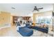 Open-concept living room featuring a kitchen view, large windows, tile flooring, and neutral colors creates a spacious interior at 442 Anessa Rose Loop, Ocoee, FL 34761
