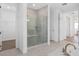 Modern glass shower with a built-in seat and bright white tile, complementing the adjacent bathroom at 4709 Flagstaff Ct, Orlando, FL 32820