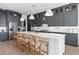 Gourmet kitchen with gray cabinets, a white island, stainless appliances, and modern lighting at 4709 Flagstaff Ct, Orlando, FL 32820